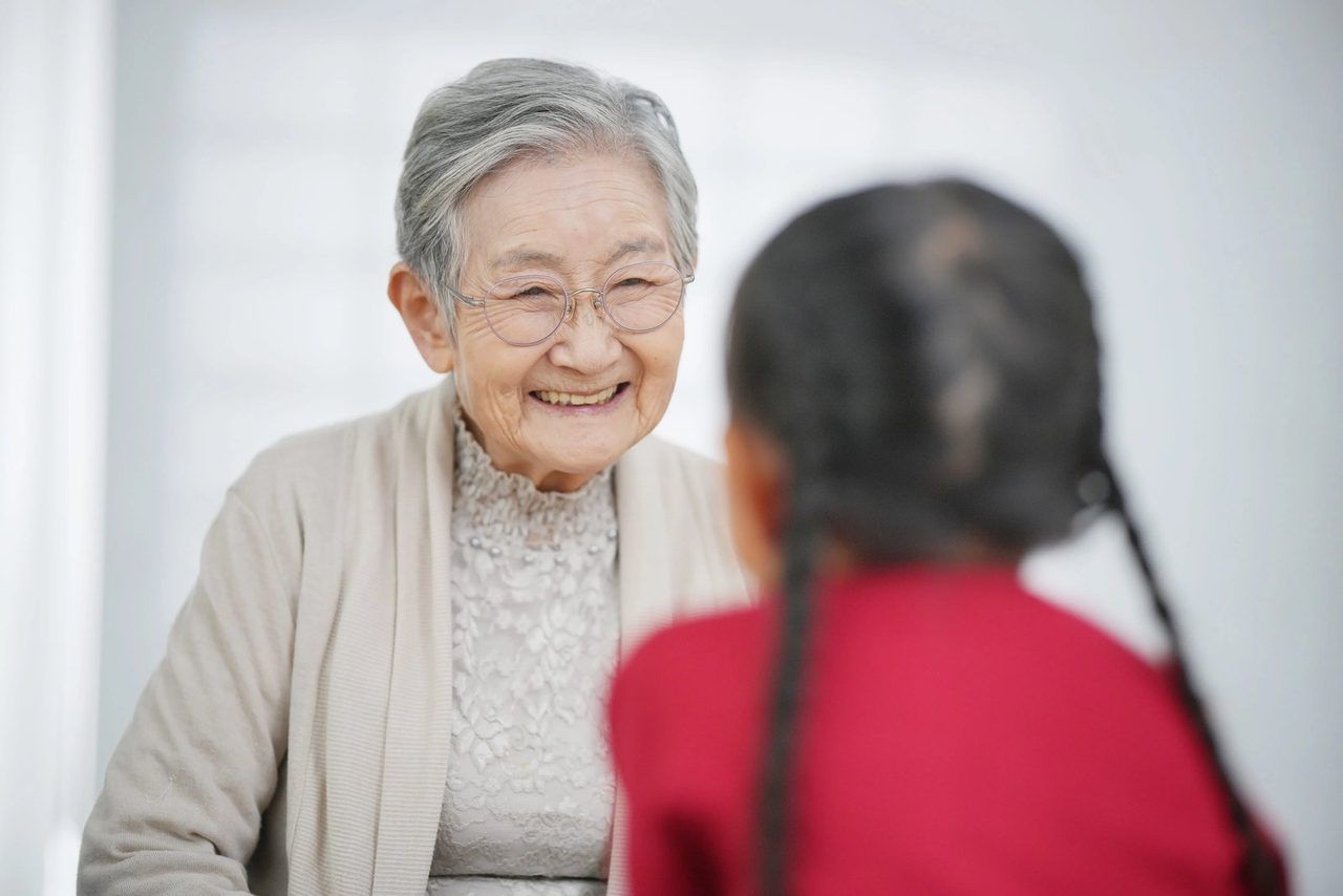 ご高齢の女性と、小さな女の子が寄り添っているイ場面