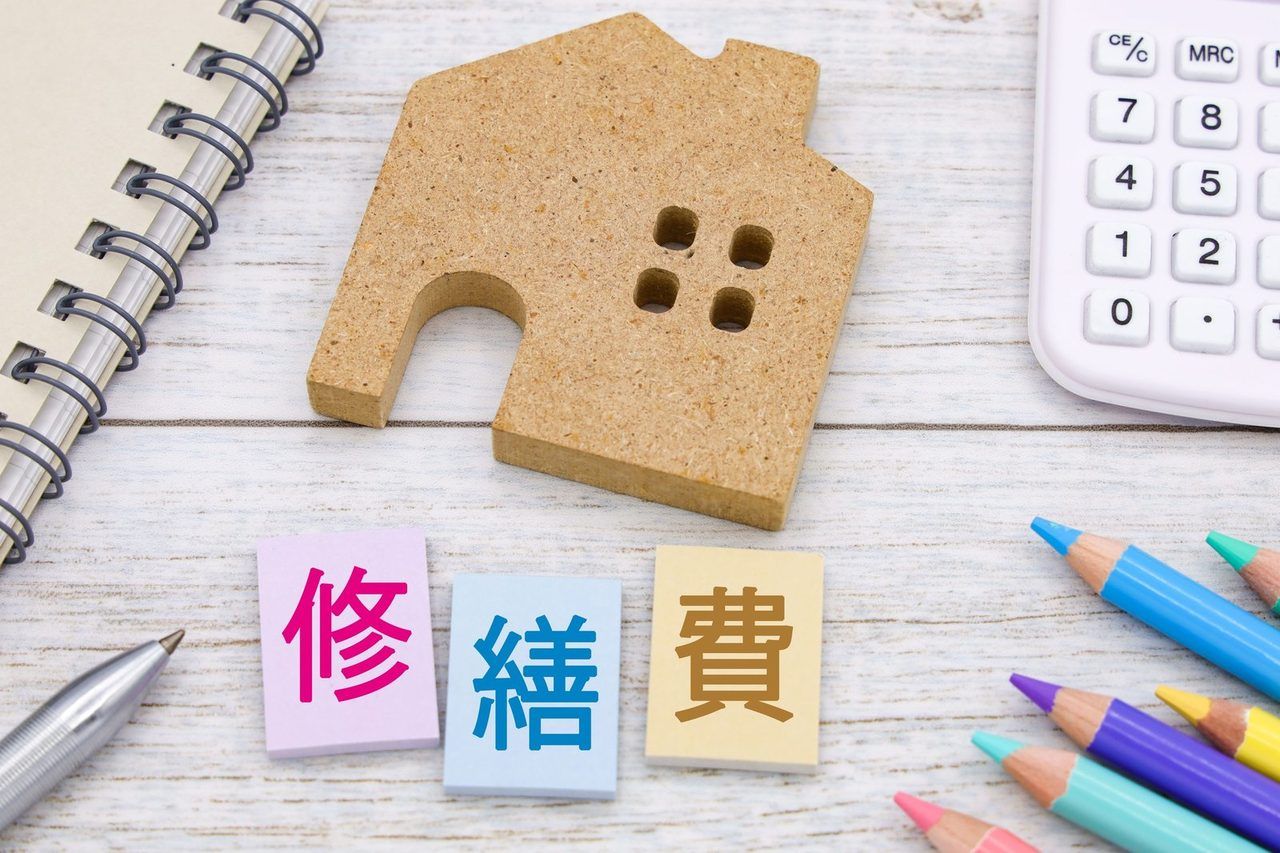 おうちの模型と「修繕費」と書かれた付箋、色鉛筆