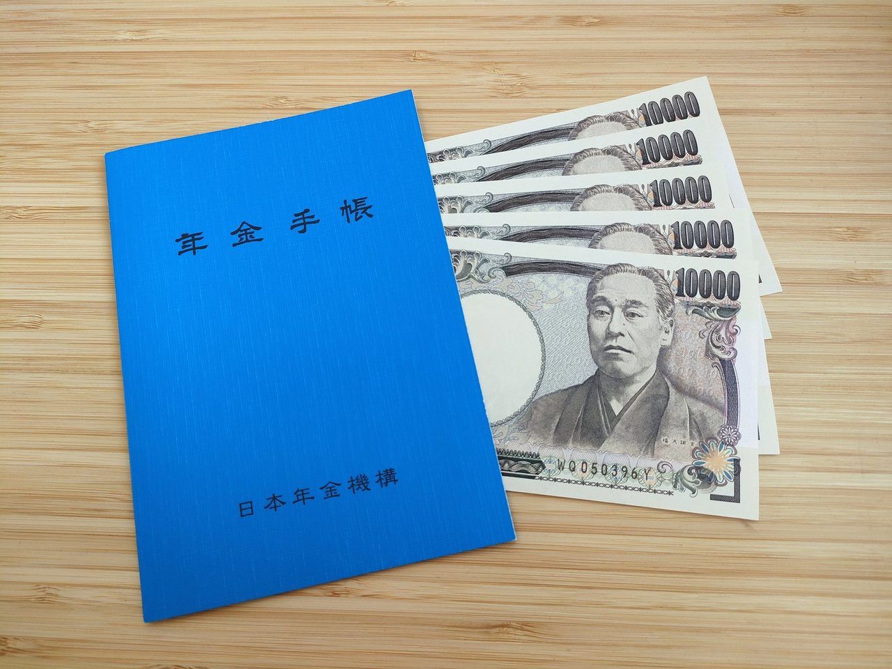 年金手帳とお札、電卓