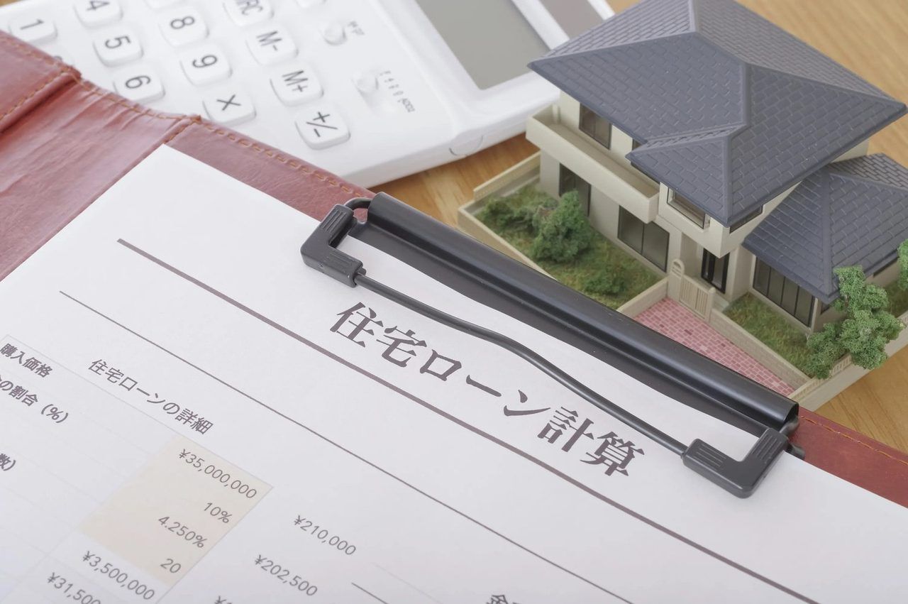「住宅ローン計算」の書類と、おうちの模型、電卓