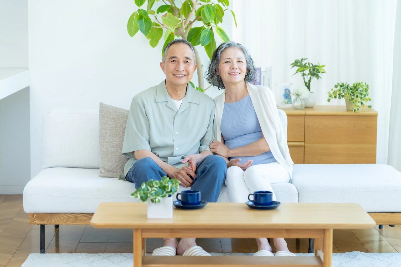 ソファで寄り添い、くつろぐご高齢のご夫婦