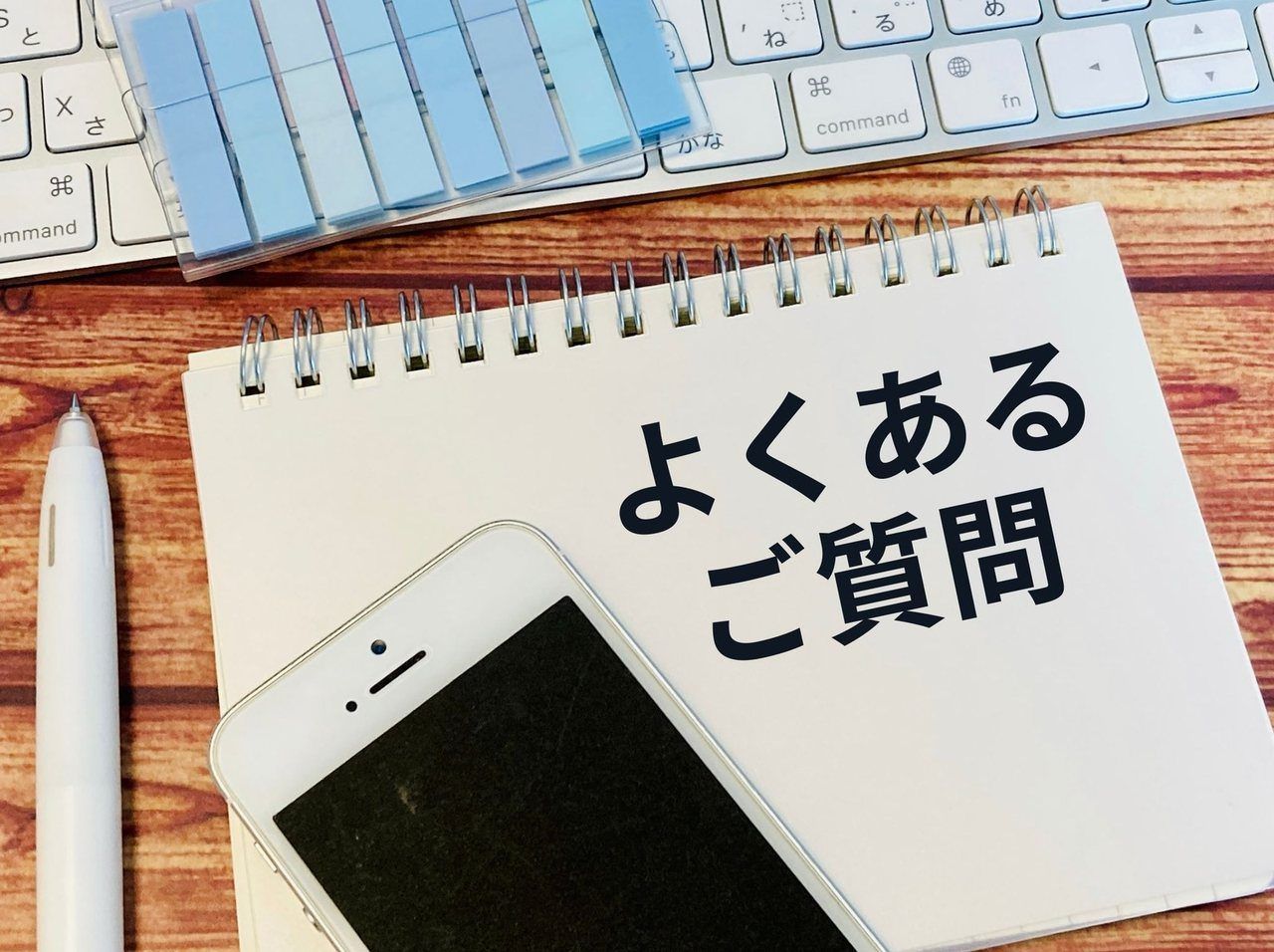 「よくあるご質問」のノートとスマートフォン