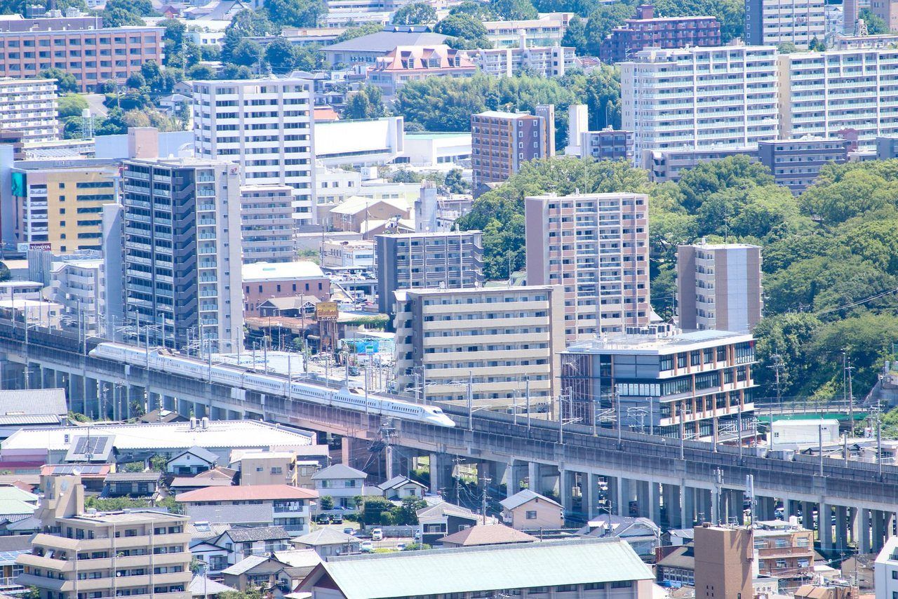 マンションが並ぶ街並みと高架を走る列車