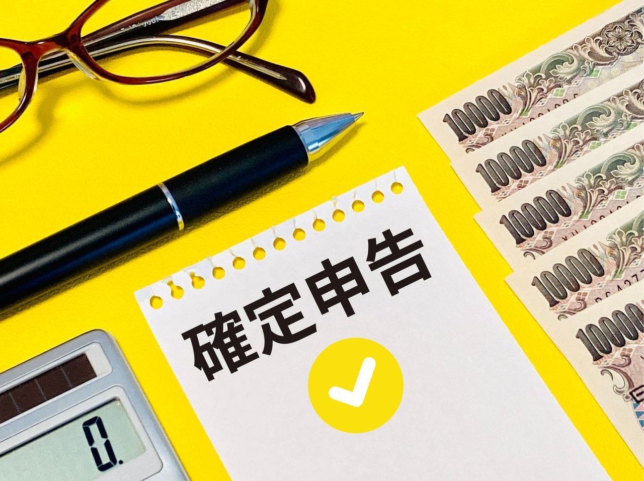 「確定申告」のメモとお札、電卓
