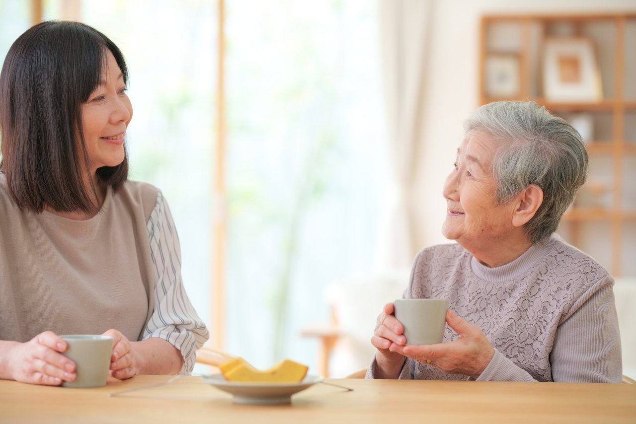 お茶を飲みながら、ご高齢の女性と娘さんが話している場面