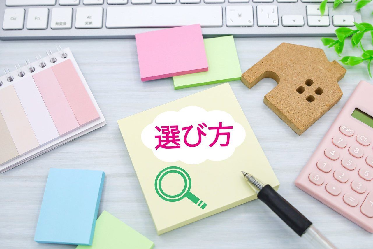 「選び方」のメモと家の置物、電卓
